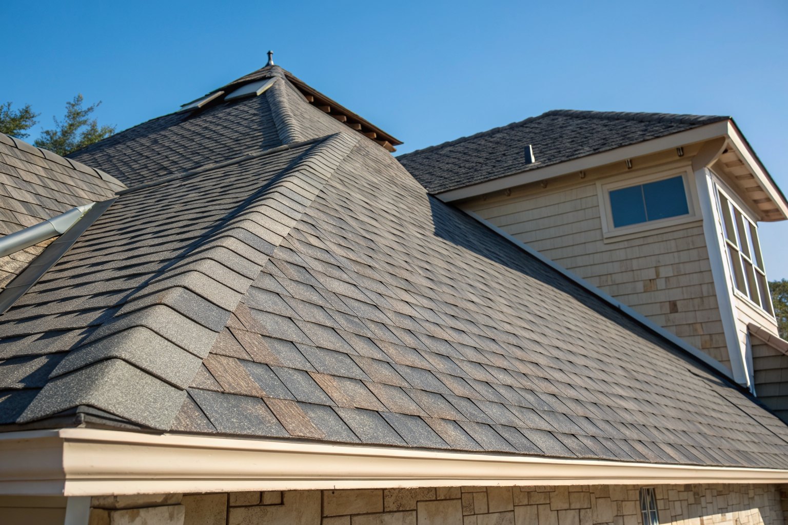 Close view of thick new architectural shingles and a ridge cap in bright sun